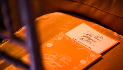 An event venue spaces program placed on a red chair under warm lighting.