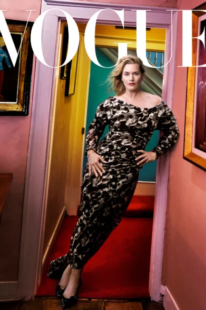 A woman in a patterned dress posing for a Vogue magazine cover in an eclectic event venue space.