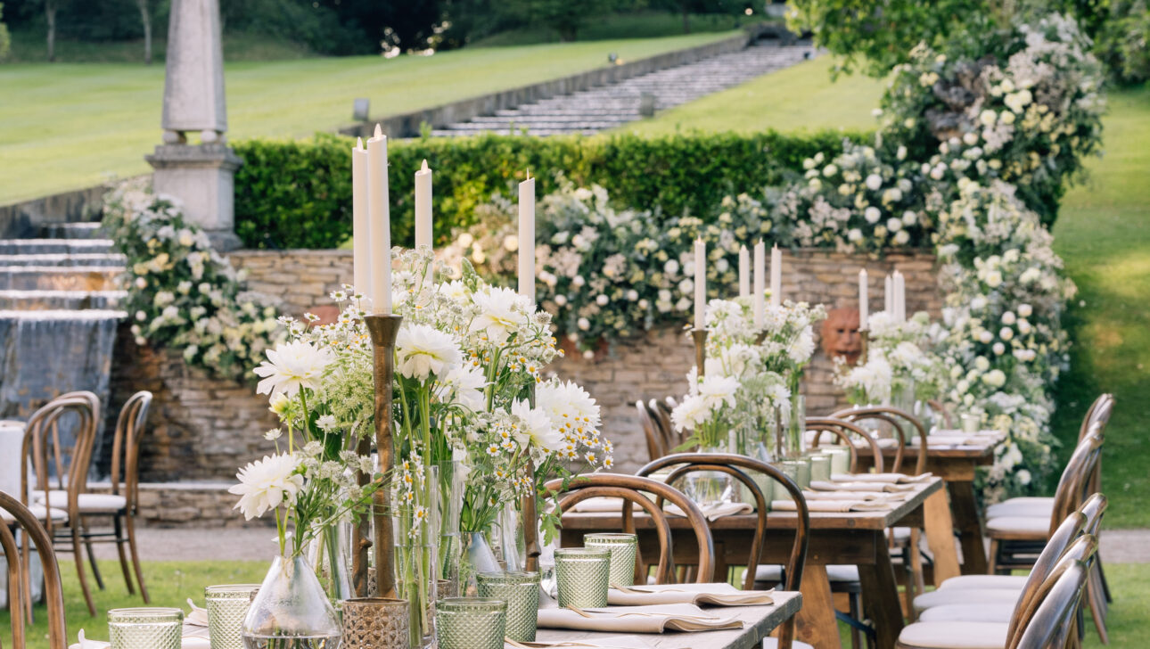 Wedding welcome dinner in beautiful outdoor garden with crisp white linens and white flowers. Designed by JWennes Events.